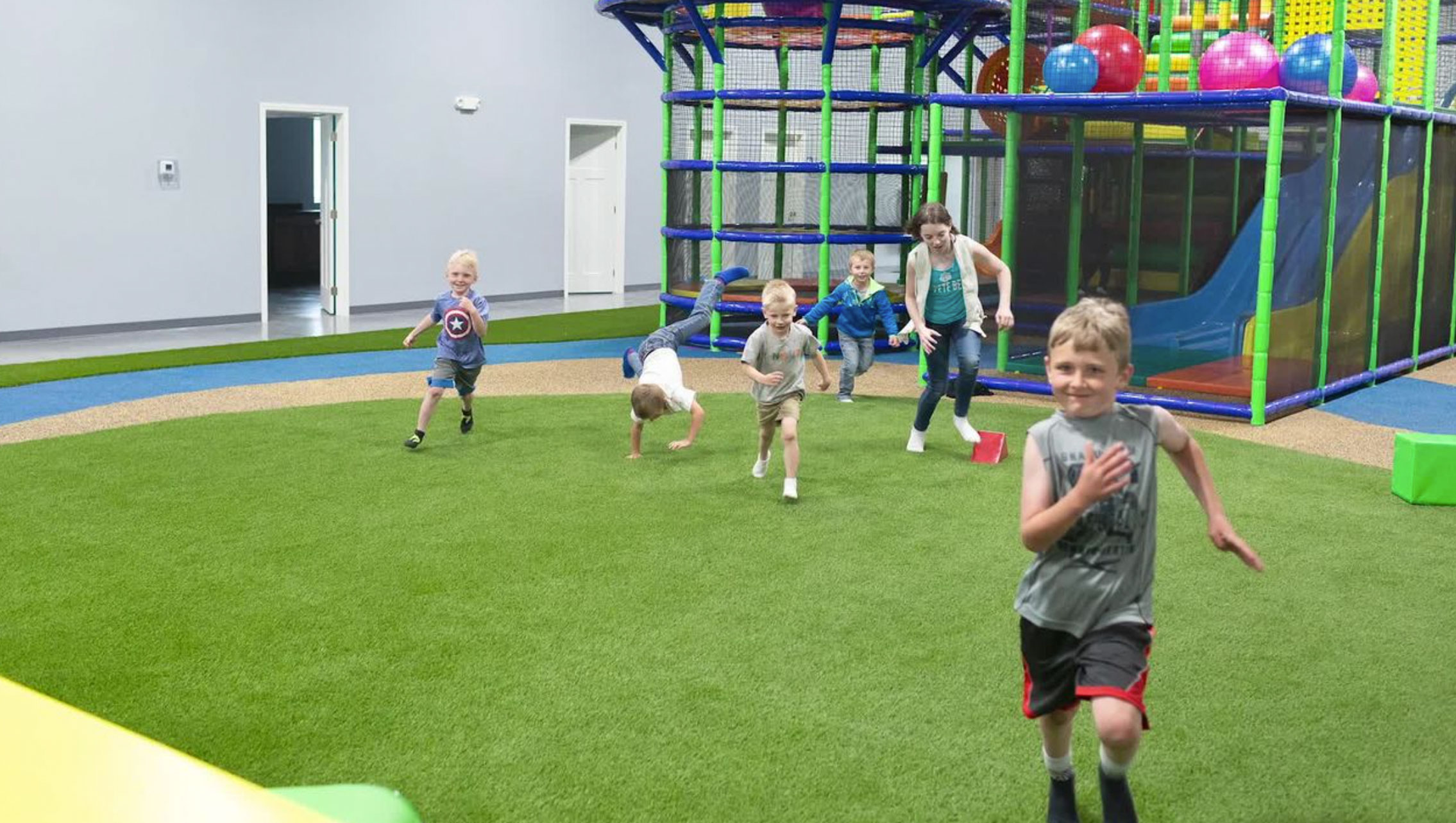 image of children playing on a playground made with synlawn turf