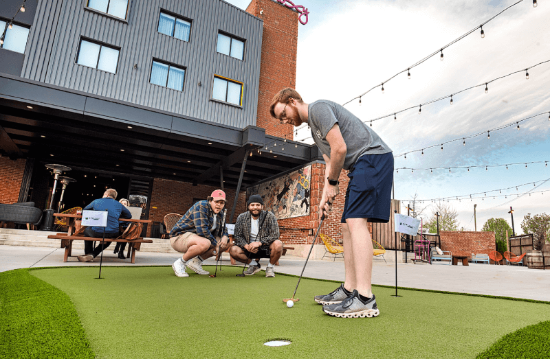 image of a group of men putting on SYNLawn artificial turf