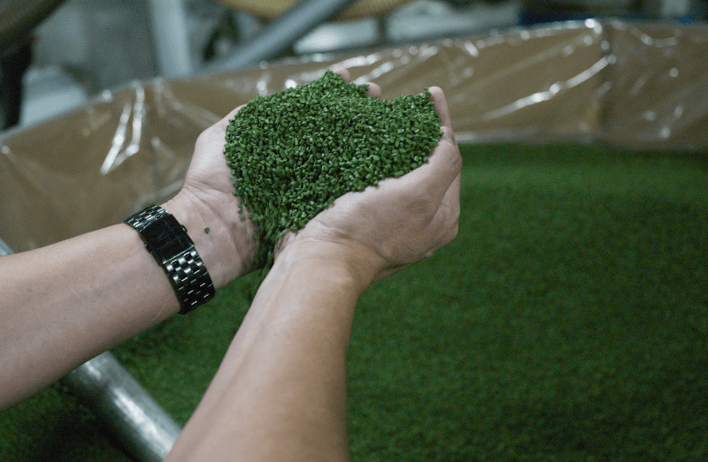 hands holding pieces from SYNLawn artificial turf