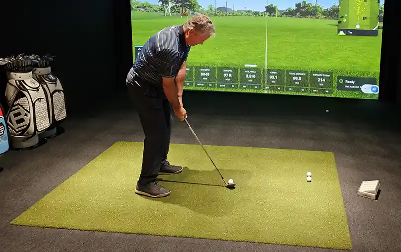 image of a man golfing on a simulator with SYNLawn artificial turf