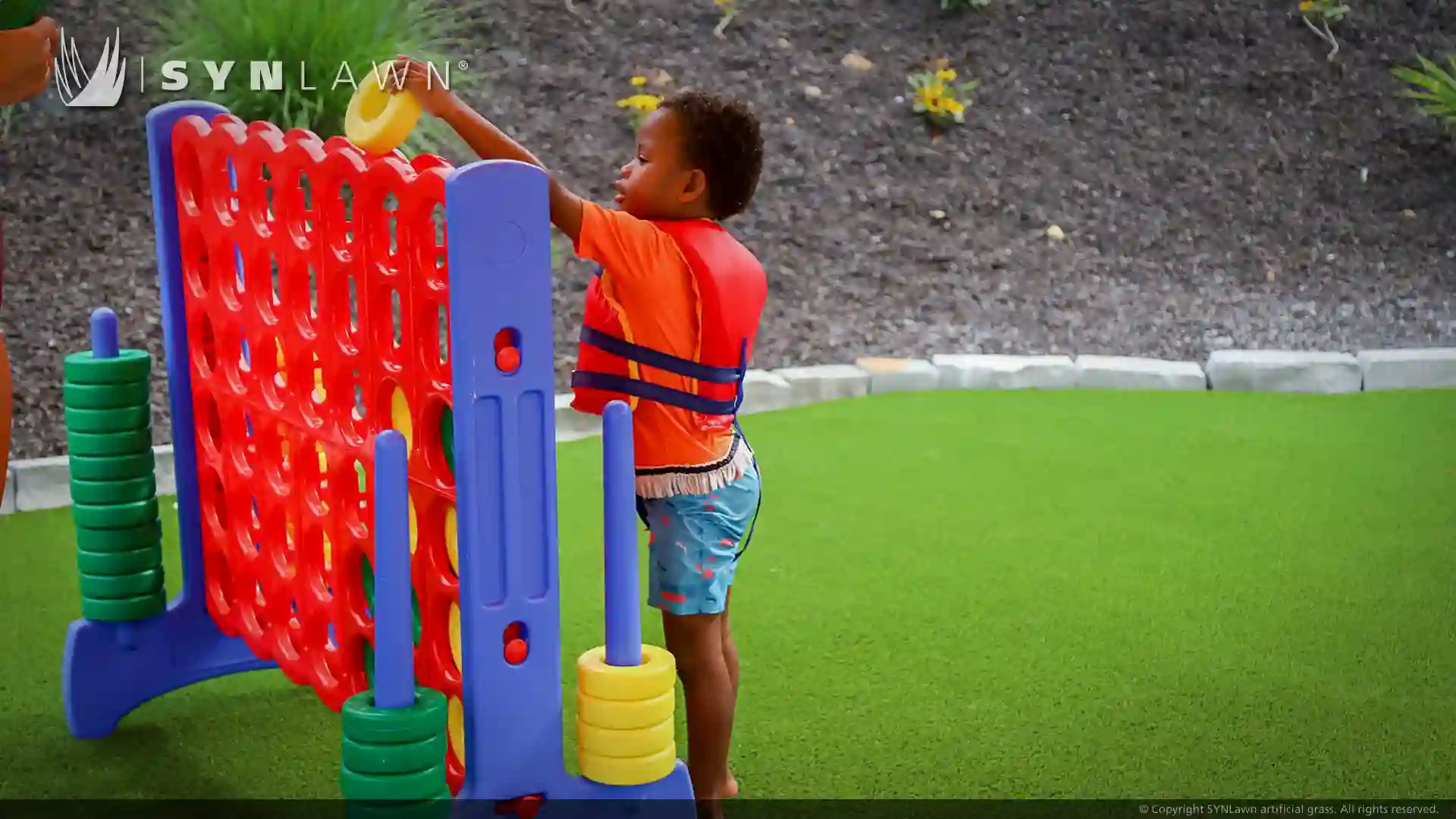 image of children and teenagers playing on artificial grass at victory junction camp water park North Carolina