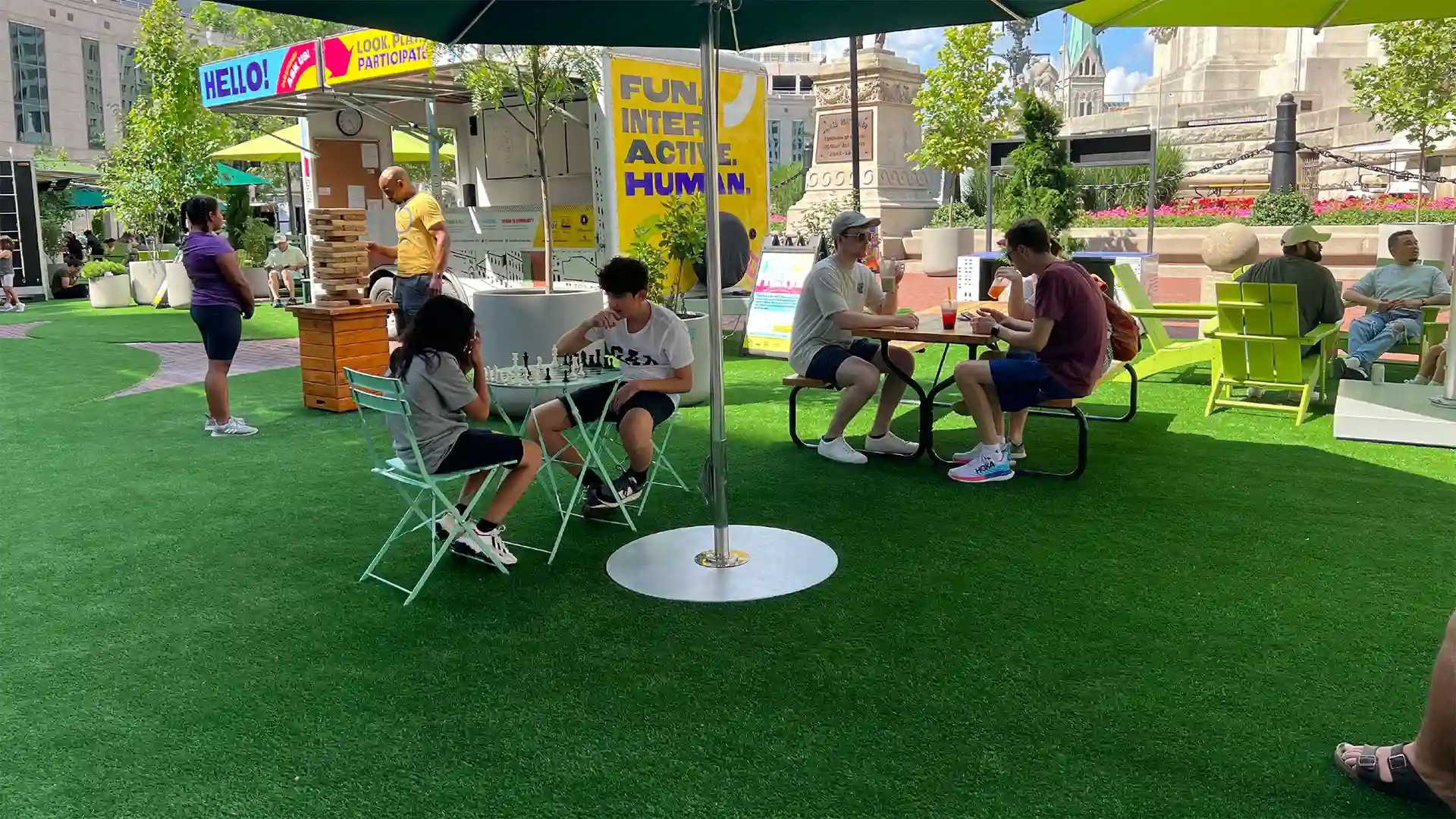 image of people enjoying lunch and playing chess on SYNLawn artificial grass at historic Monument Circle Park Indianapolis Indiana