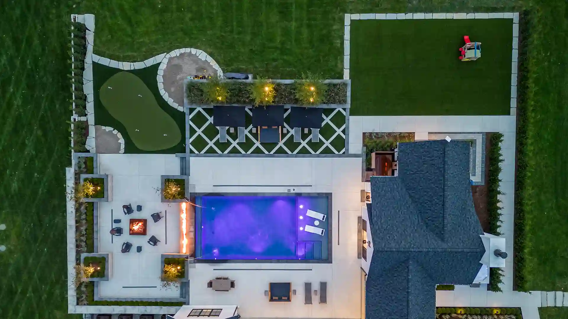 image of SYNLawn artificial grass landscape backyard design with custom putting green and paver design at upscale luxury home in Rochester Hills Michigan